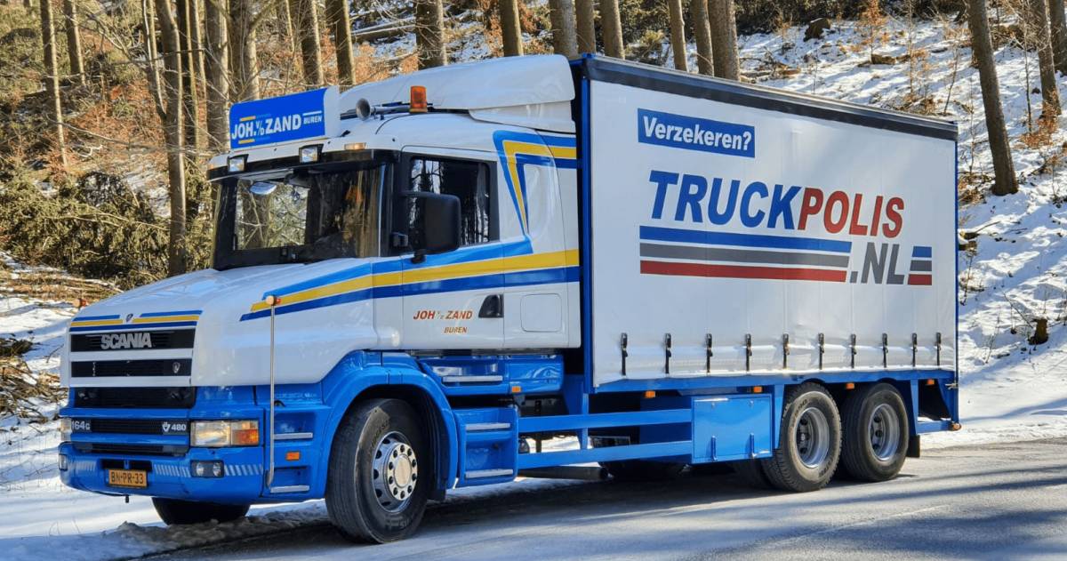 Een vrachtwagen met reclame van truckpolis.nl